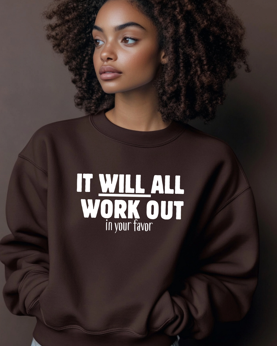 Woman wearing a brown sweatshirt with motivational text against a dark background